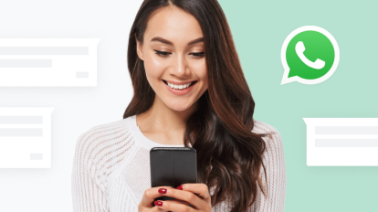 Une personne souriante utilisant son téléphone pour lire des messages WhatsApp