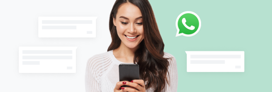 Une personne souriante utilisant son téléphone pour lire des messages WhatsApp