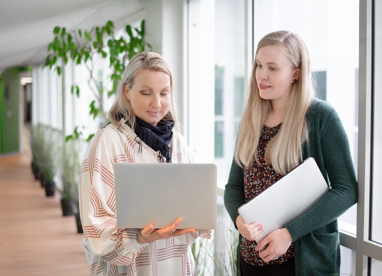 Personnes souriantes utilisant l'outil d'email marketing B2B LianaMailer sur un ordinateur portable.