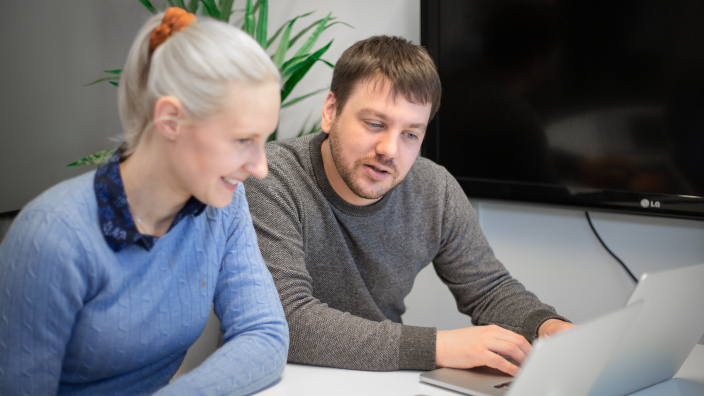 Deux personnes utilisant l'outil d'email marketing LianaMailer sur un ordinateur portable