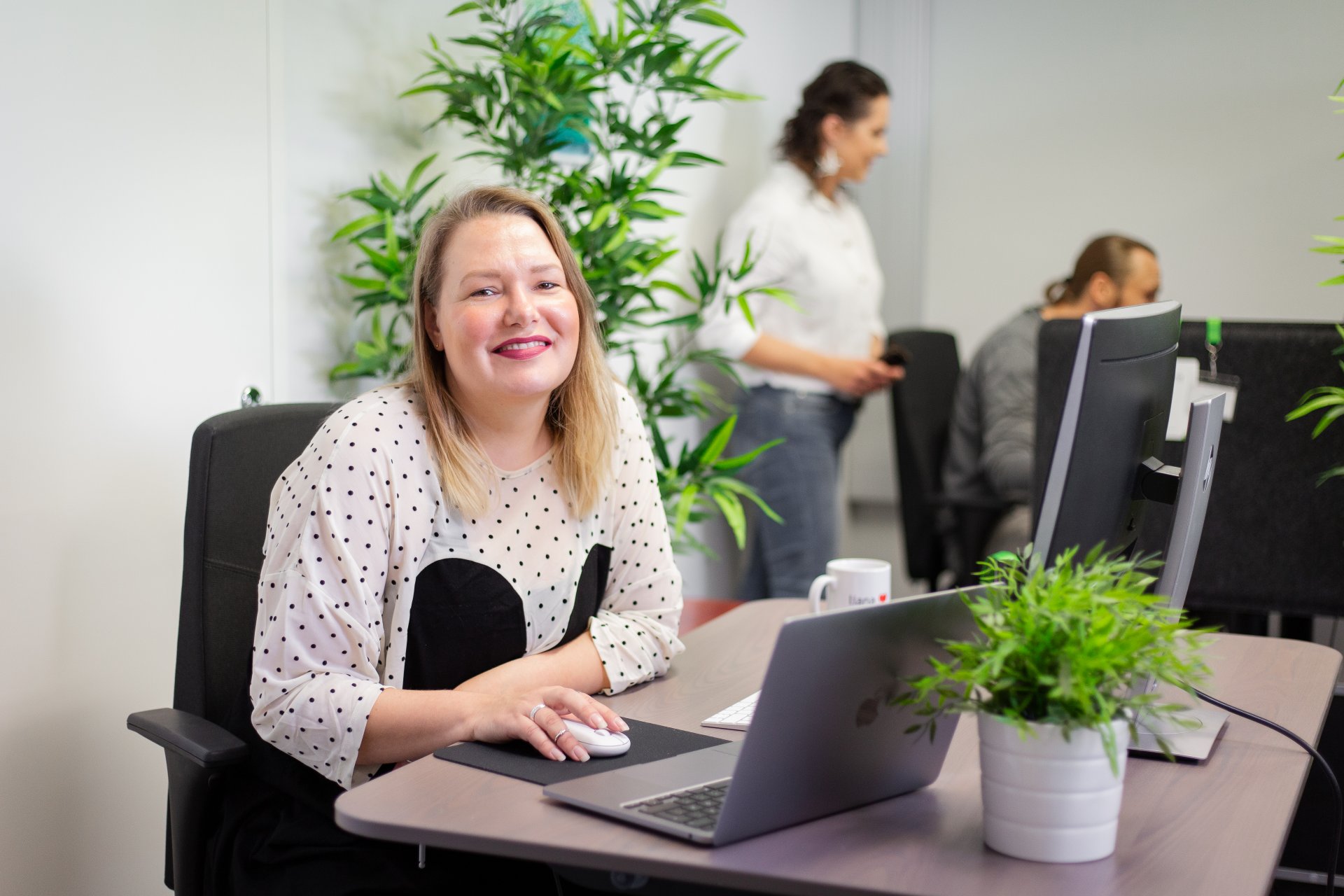 Une personne souriante utilisant l'outil de newsletter LianaMailer sur son ordinateur portable.