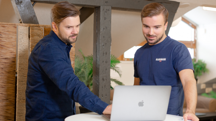 Deux personnes utilisant l'outil d'email marketing LianaMailer sur un ordinateur portable