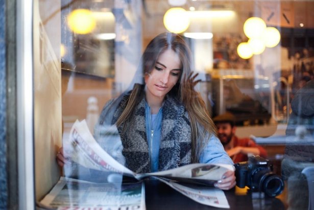 Femme lisant un journal dans un restaurant